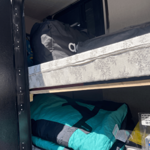 Travel trailer bunk beds repurposed for duffel bag and gear storage
